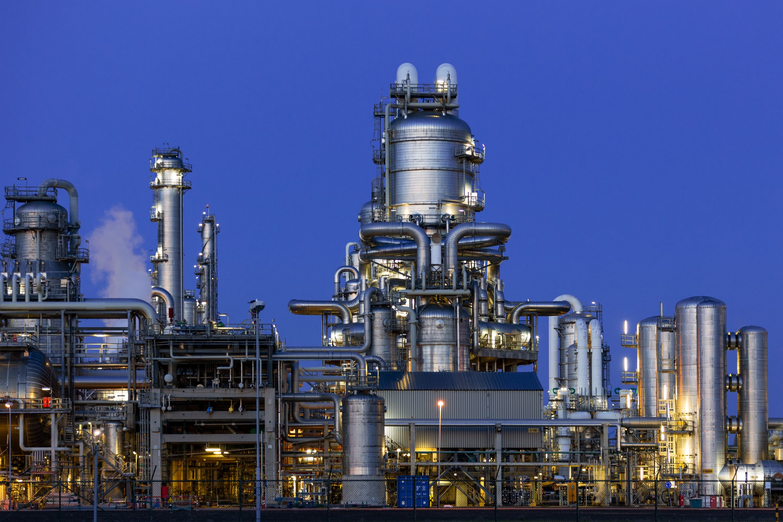 A modern industrial refinery structure under a clear twilight sky in Zuid-Holland, Netherlands.